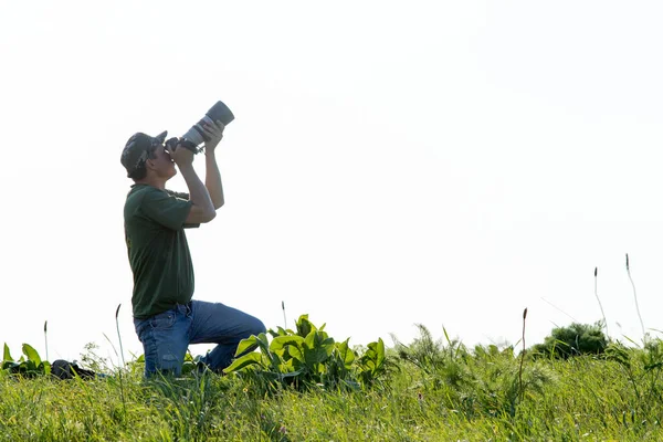 Shymkent, Kazakistan - 04 Mayıs 2017: kamera ile adam manzara vuruyor. Yeşil çimen, beyaz arka plan.