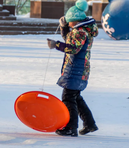 Petropavlovsk, Kazakistan - 8 Ocak 2019: Çocuk buzlu bir tepede binmek. Yetişkinler ve çocuklar parkta birlikte sakin ol.