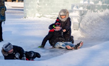 Petropavlovsk, Kazakistan - 8 Ocak 2019: Çocuk buzlu bir tepede binmek. Yetişkinler ve çocuklar parkta birlikte sakin ol.