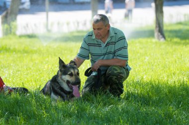Shymkent, Kazakistan - 13 Mayıs 2017: Şehir Parkı bir köpek ile bir adam.