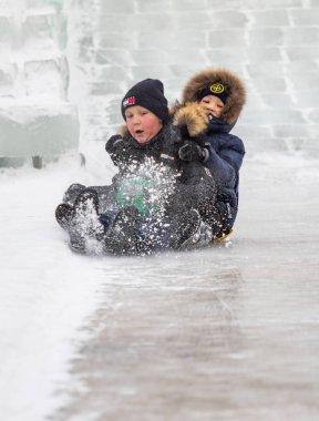 Petropavlovsk, Kazakistan - 13 Ocak 2019: Çocuk buzlu bir tepede binmek. Yetişkinler ve çocuklar parkta birlikte sakin ol.