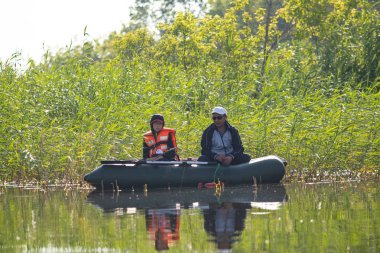 Petropavlovsk, Kazakistan - 28 Temmuz 2018: İnsanlar göl kenarında lastik gemilerde balıkçılar, balık. Lake Pestroe, Petropavlovsk, Kazakistan.