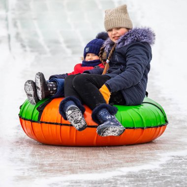 Petropavlovsk, Kazakistan - 13 Ocak 2019: Çocuk buzlu bir tepede binmek. Yetişkinler ve çocuklar parkta birlikte sakin ol.