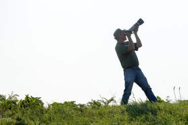 Shymkent, Kazakistan - 04 Mayıs 2017: kamera ile adam manzara vuruyor. Yeşil çimen, beyaz arka plan.