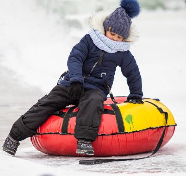 Petropavlovsk, Kazakistan - 13 Ocak 2019: Çocuk buzlu bir tepede binmek. Yetişkinler ve çocuklar parkta birlikte sakin ol.