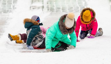 Petropavlovsk, Kazakistan - 13 Ocak 2019: Çocuk buzlu bir tepede binmek. Yetişkinler ve çocuklar parkta birlikte sakin ol.