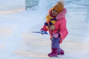 Petropavlovsk, Kazakistan - 8 Ocak 2019: Çocuk buzlu bir tepede binmek. Yetişkinler ve çocuklar parkta birlikte sakin ol.