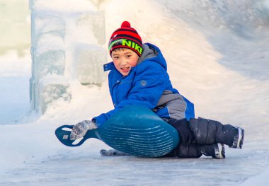 Petropavlovsk, Kazakistan - 8 Ocak 2019: Çocuk buzlu bir tepede binmek. Yetişkinler ve çocuklar parkta birlikte sakin ol.