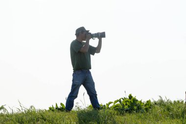Shymkent, Kazakistan - 04 Mayıs 2017: kamera ile adam manzara vuruyor. Yeşil çimen, beyaz arka plan.