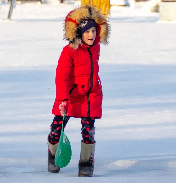 Petropavlovsk, Kazakistan - 8 Ocak 2019: Çocuk buzlu bir tepede binmek. Yetişkinler ve çocuklar parkta birlikte sakin ol.