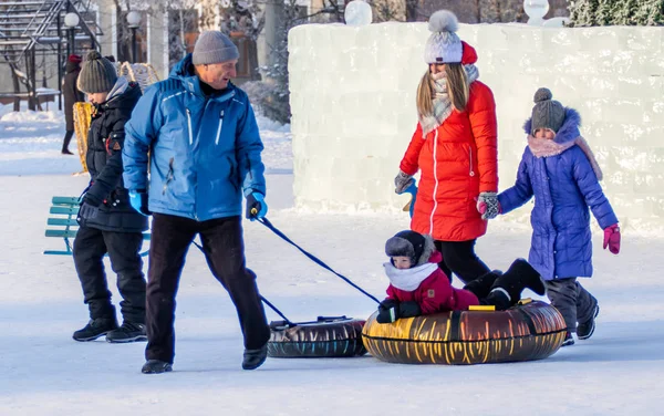 Petropavlovsk, Kazakistan - 8 Ocak 2019: Çocuk buzlu bir tepede binmek. Yetişkinler ve çocuklar parkta birlikte sakin ol.