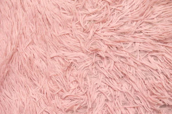fur rug. Pink natural wool with twists texture background. Cotton wool, white fleece carpet