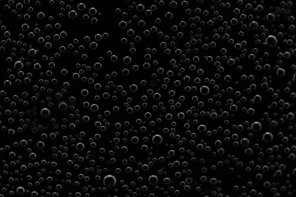 round air droplets in water on a black background