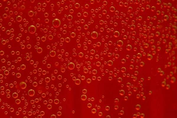 round air droplets in water on a red background