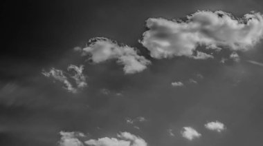 Beyaz bulutların üzerinde karanlık bir gökyüzü, tek renkli.