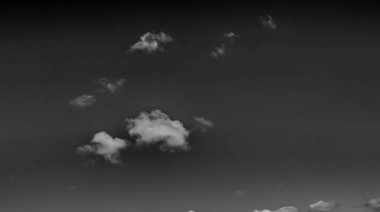 Beyaz bulutların üzerinde karanlık bir gökyüzü, tek renkli.