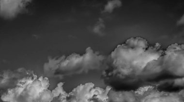 Beyaz bulutların üzerinde karanlık bir gökyüzü, tek renkli.