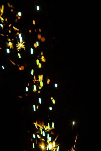 Defocused, sparks of fire on a black background, bright bokeh, blurred background of fire.