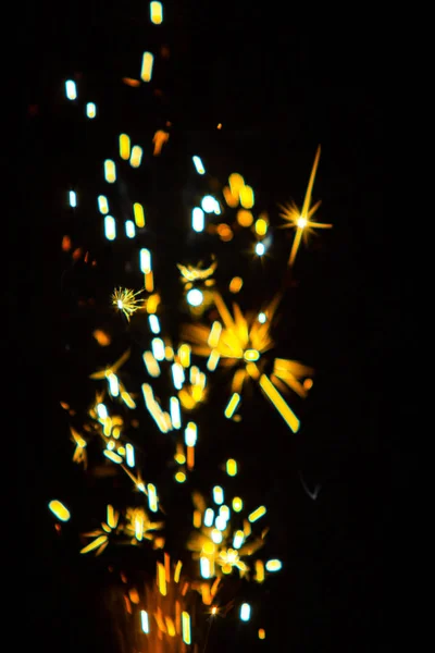 Defocused, sparks of fire on a black background, bright bokeh, blurred background of fire.