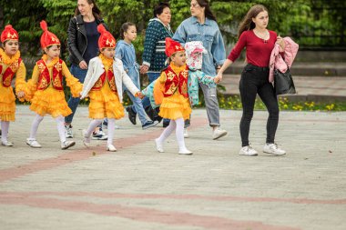 Petropavlovsk, Kazakistan-1 Haziran 2019: Uluslararası Çocuk günü. Şehir sokaklarında okul öğrencileri geçit töreni. Ulusal tatil kıyafetlerinin içinde çocuklar ve ebeveynler. Dans tatil şarkıları.