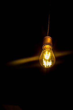 Siyah arka plan üzerinde elektrikli lamba eski sarı ışık, sanat