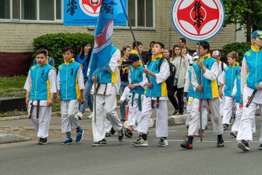 Petropavlovsk, Kazakistan-1 Haziran 2019: Uluslararası Çocuk günü. Şehir sokaklarında okul öğrencileri geçit töreni. Ulusal tatil kıyafetlerinin içinde çocuklar ve ebeveynler. Dans tatil şarkıları.