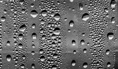 Cam üzerinde yağmur damlaları, siyah-beyaz arka plan, moda cam doku.