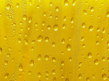 Cam su damlaları, sarı arka plan bira, buğulu arka plan.