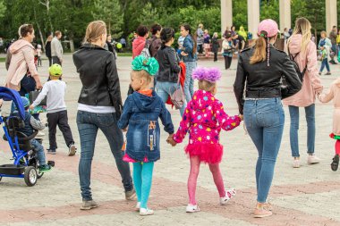 Petropavlovsk, Kazakistan-1 Haziran 2019: Uluslararası Çocuk günü. Şehir sokaklarında okul öğrencileri geçit töreni. Ulusal tatil kıyafetlerinin içinde çocuklar ve ebeveynler. Dans tatil şarkıları.