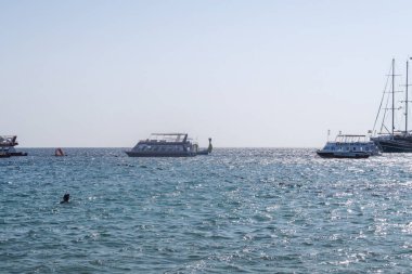 Şarm El-Şeyh, Mısır-11 Kasım 2017: Sharm El-Sheikh, Egypt 'te Naama Körfezi Denizi Plajı. İnsanlar yıkanmak, dinlenmek. Tekneler denizde yelken.