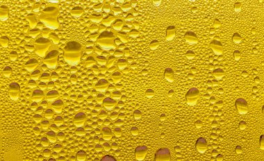 Cam su damlaları, sarı arka plan bira, buğulu arka plan.