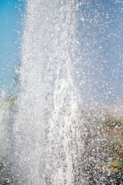 Mavi gökyüzüne karşı Su Çeşmesi sprey. Su sıçramaları odak dışında.