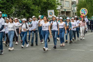 Petropavlovsk, Kazakistan-1 Haziran 2019: Uluslararası Çocuk günü. Şehir sokaklarında okul öğrencileri geçit töreni. Ulusal tatil kıyafetlerinin içinde çocuklar ve ebeveynler. Dans tatil şarkıları.