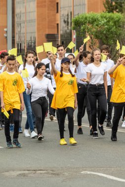 Petropavlovsk, Kazakistan-1 Haziran 2019: Uluslararası Çocuk günü. Şehir sokaklarında okul öğrencileri geçit töreni. Ulusal tatil kıyafetlerinin içinde çocuklar ve ebeveynler. Dans tatil şarkıları.