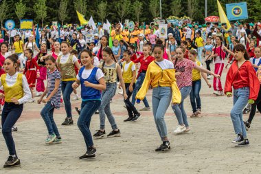 Petropavlovsk, Kazakistan-1 Haziran 2019: Uluslararası Çocuk günü. Şehir sokaklarında okul öğrencileri geçit töreni. Ulusal tatil kıyafetlerinin içinde çocuklar ve ebeveynler. Dans tatil şarkıları.