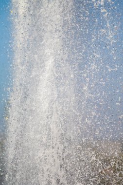 Mavi gökyüzüne karşı Su Çeşmesi sprey. Su sıçramaları odak dışında.