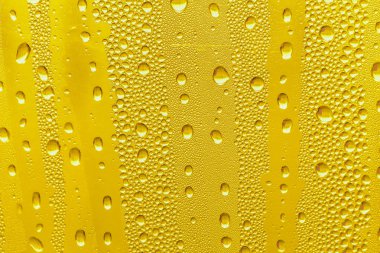 Cam su damlaları, sarı arka plan bira, buğulu arka plan.