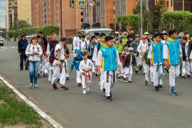 Petropavlovsk, Kazakistan-1 Haziran 2019: Uluslararası Çocuk günü. Şehir sokaklarında okul öğrencileri geçit töreni. Ulusal tatil kıyafetlerinin içinde çocuklar ve ebeveynler. Dans tatil şarkıları.