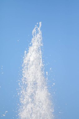 Mavi gökyüzüne karşı Su Çeşmesi sprey. Su sıçramaları odak dışında.