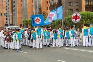 Petropavlovsk, Kazakistan-1 Haziran 2019: Uluslararası Çocuk günü. Şehir sokaklarında okul öğrencileri geçit töreni. Ulusal tatil kıyafetlerinin içinde çocuklar ve ebeveynler. Dans tatil şarkıları.