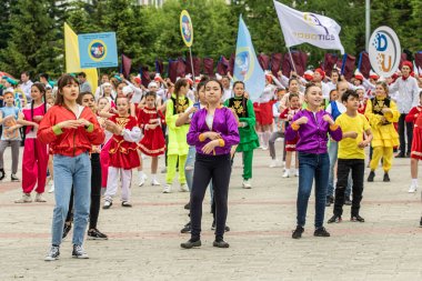 Petropavlovsk, Kazakistan-1 Haziran 2019: Uluslararası Çocuk günü. Şehir sokaklarında okul öğrencileri geçit töreni. Ulusal tatil kıyafetlerinin içinde çocuklar ve ebeveynler. Dans tatil şarkıları.