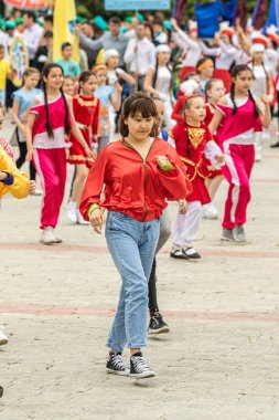 Petropavlovsk, Kazakistan-1 Haziran 2019: Uluslararası Çocuk günü. Şehir sokaklarında okul öğrencileri geçit töreni. Ulusal tatil kıyafetlerinin içinde çocuklar ve ebeveynler. Dans tatil şarkıları.