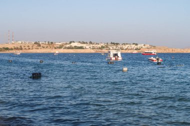 Şarm El-Şeyh, Mısır-11 Kasım 2017: Sharm El-Sheikh, Egypt 'te Naama Körfezi Denizi Plajı. İnsanlar yıkanmak, dinlenmek. Tekneler denizde yelken.