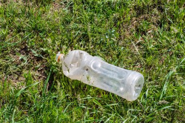 Yeşil çim, çevre kirliliği üzerinde plastik çöp atık.