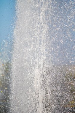 Mavi gökyüzüne karşı Su Çeşmesi sprey. Su sıçramaları odak dışında.