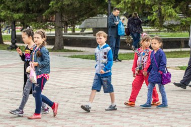 Petropavlovsk, Kazakistan-1 Haziran 2019: Uluslararası Çocuk günü. Şehir sokaklarında okul öğrencileri geçit töreni. Ulusal tatil kıyafetlerinin içinde çocuklar ve ebeveynler. Dans tatil şarkıları.