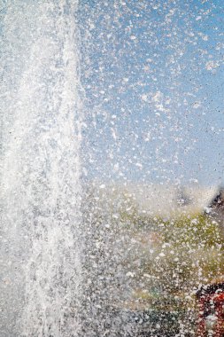 Mavi gökyüzüne karşı Su Çeşmesi sprey. Su sıçramaları odak dışında.