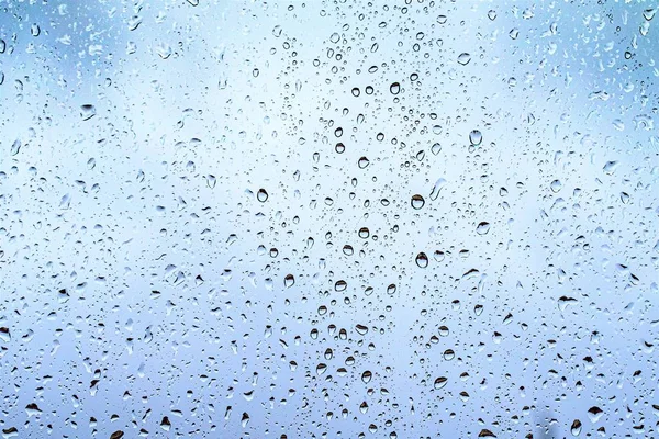 玻璃上的雨滴 窗外深蓝色的天空背景 — 图库照片