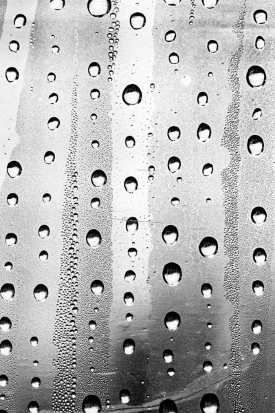 Raindrops on the glass, black-white background, fashion glass texture.