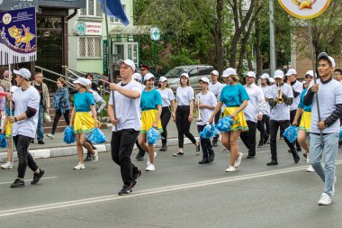 Petropavlovsk, Kazakistan-1 Haziran 2019: Uluslararası Çocuk günü. Şehir sokaklarında okul öğrencileri geçit töreni. Ulusal tatil kıyafetlerinin içinde çocuklar ve ebeveynler. Dans tatil şarkıları.